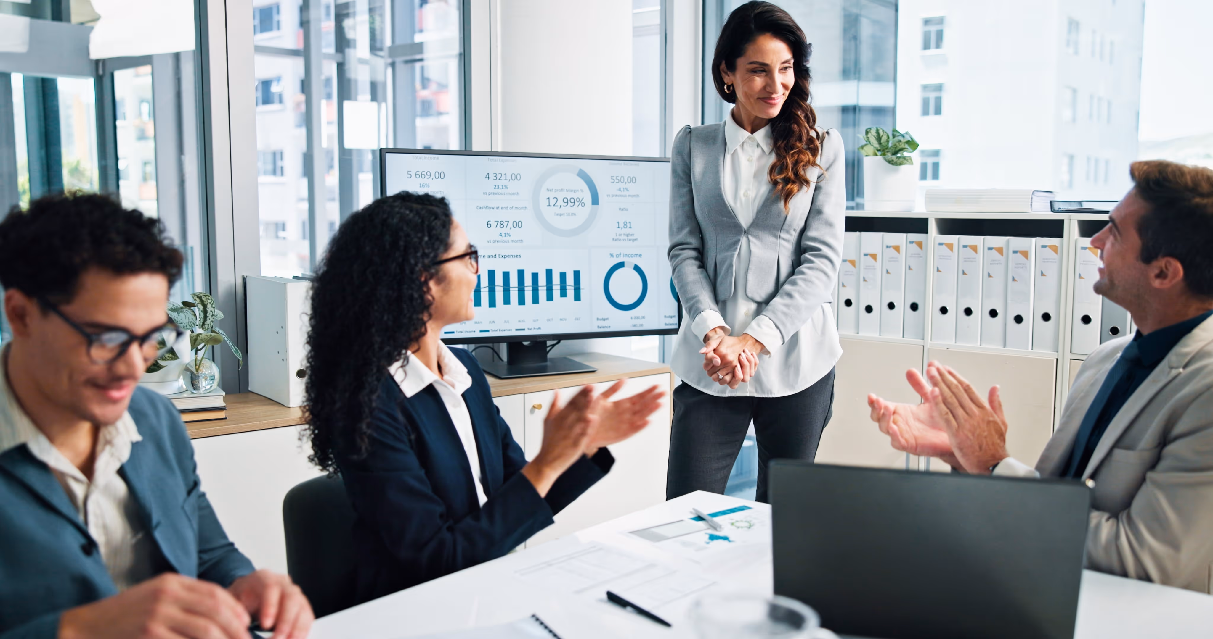 A female worker makes a presentation in a boardroom to her team